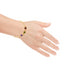 A hand adorned with the "Red Green and Purple Gemstone Link Bracelet 18k Gold Filled" delicately showcases an array of vibrant gemstones. This lead and nickel-free piece elegantly rests on the wrist, highlighting its intricate design against a white background.